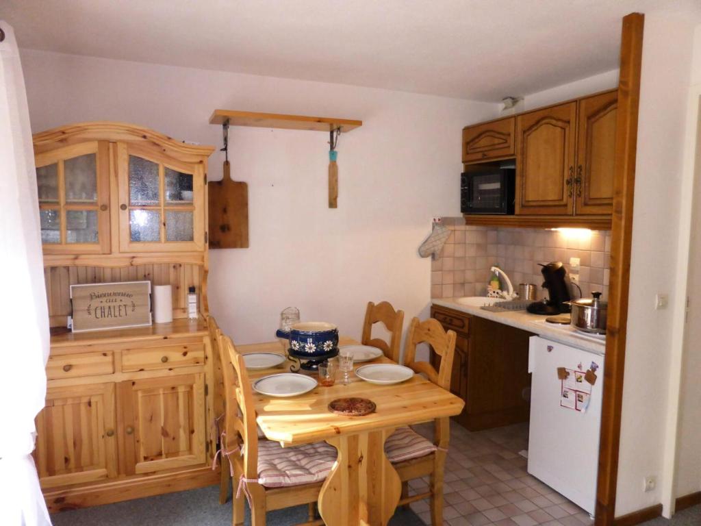 een keuken met een houten tafel en een kleine tafel en stoelen bij Résidence Les Trolles - 2 Pièces pour 4 Personnes 374 in Les Contamines-Montjoie