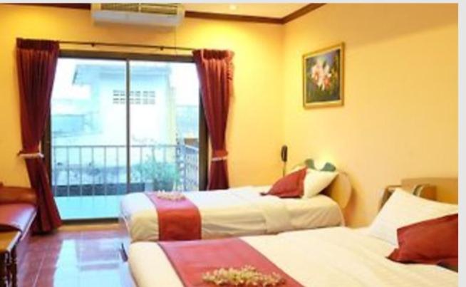 Habitación de hotel con 2 camas y ventana en the L Hua Hin en Hua Hin