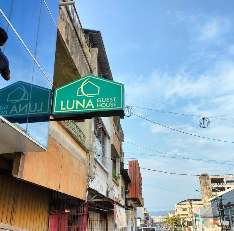 a green sign on the side of a building at Luna Guest House in Tanjungkarang-Telukbetung