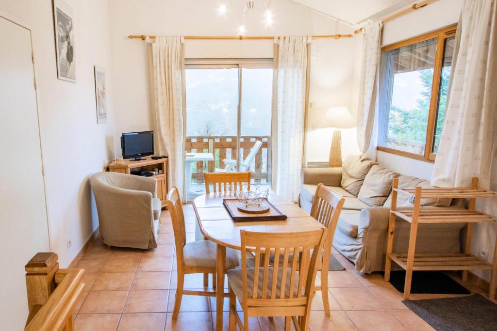 sala de estar con mesa y sillas en Les Chalets Petit Bonheur - Chalets pour 6 Personnes 474, en Villarodin-Bourget