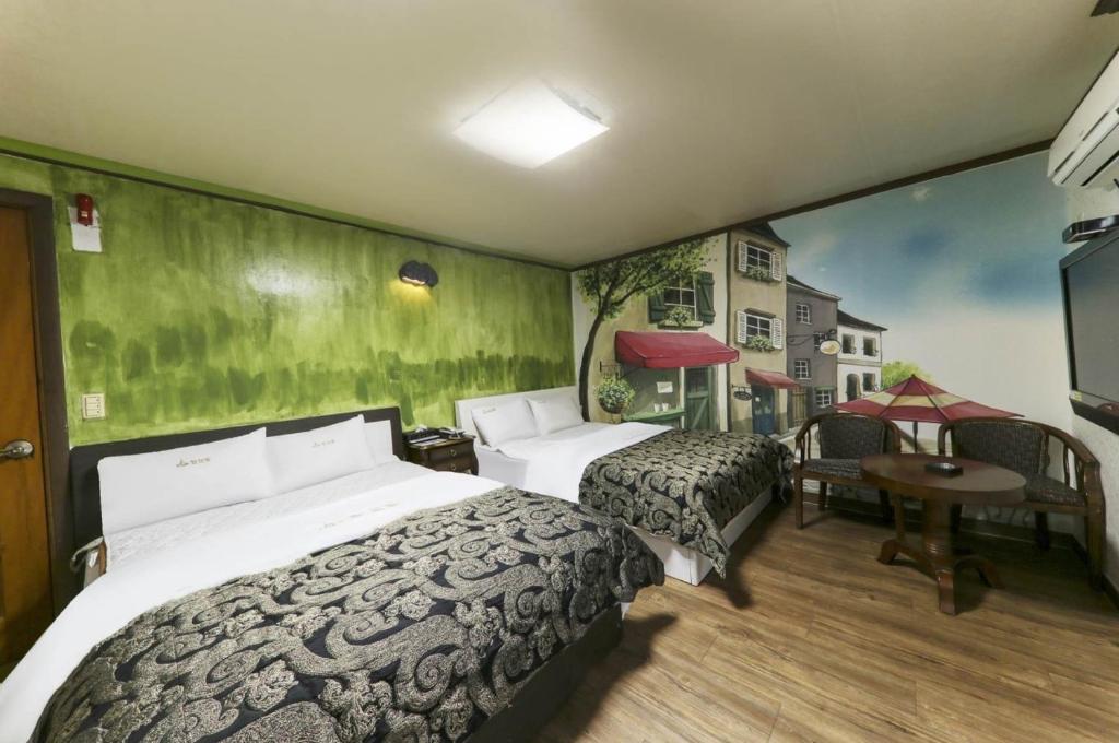 um quarto de hotel com duas camas e uma mesa em Top Motel em Suncheon
