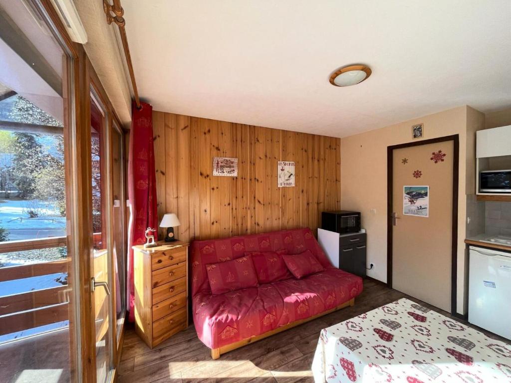 uma sala de estar com um sofá vermelho num quarto em Résidence Les Cordeliers - Studio pour 4 Personnes 171 em Valloire