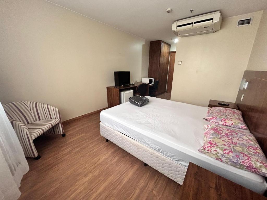 a bedroom with a bed and a chair in it at 705. Flat hotel Go Inn in Brasília
