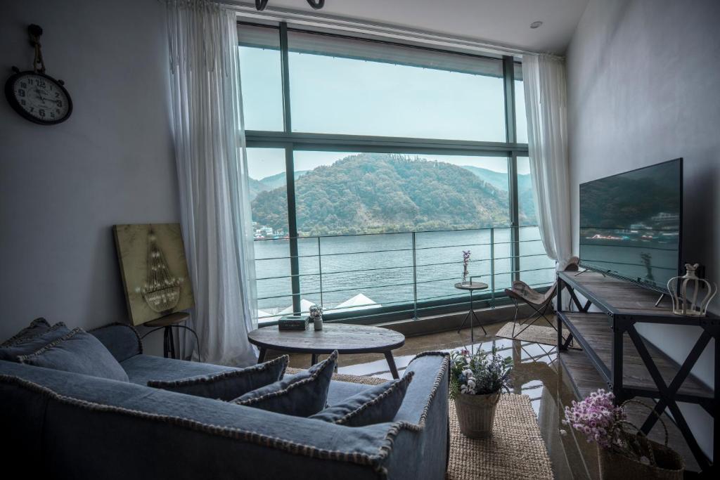 a living room with a large window with a view of the water at SS Resort in Gapyeong
