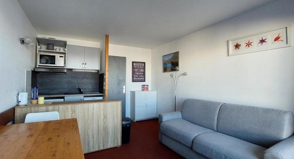 un salon avec un canapé et une cuisine dans l'établissement Résidence Ruitor Arc 1800 - Appartement 2 pièces pour 4 personnes avec un jolie vue sur la vallée, proche du télécabine dans le village de Charmettoger à Ar MAE-8681, à Arc 1800