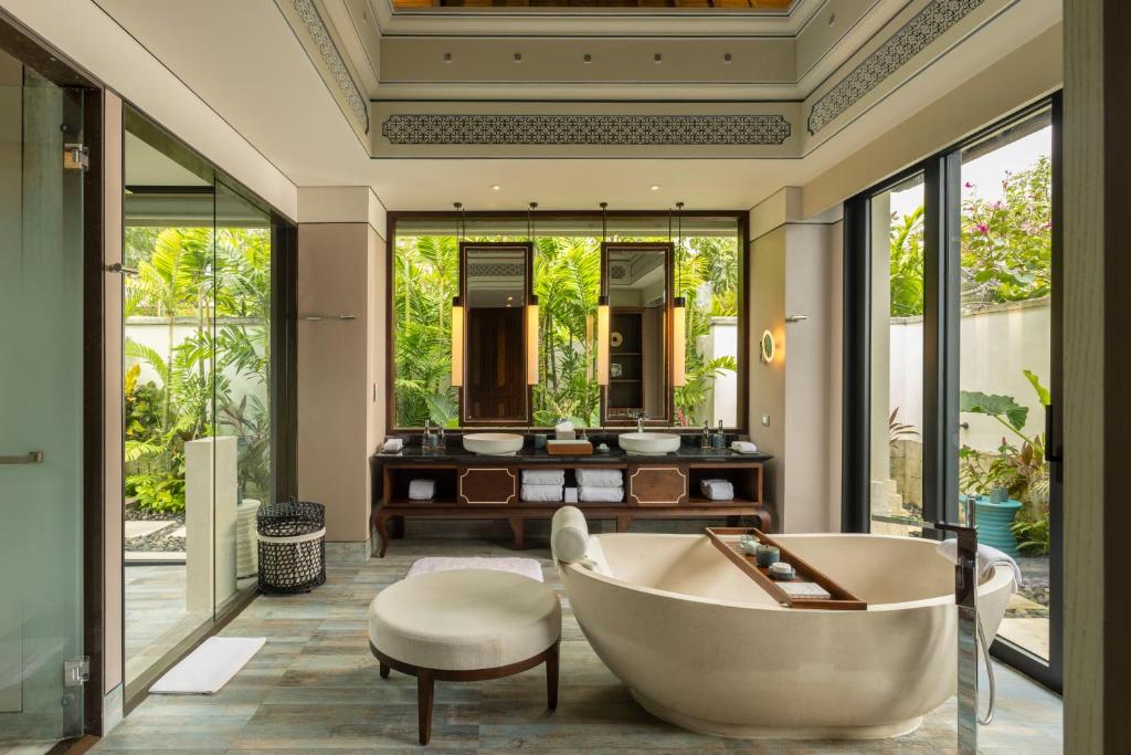 a bathroom with a tub and a sink at Jumeirah Bali in Uluwatu