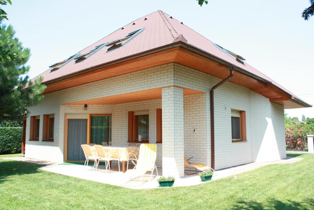 a house with a table and chairs in a yard at Manner villa in Balatonalmádi