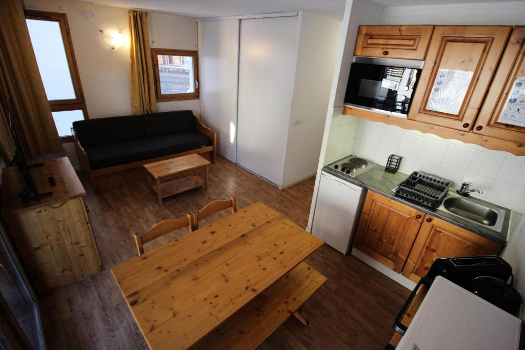 einen Blick über die Küche und einen Tisch in einem Zimmer in der Unterkunft Chalets De La Vanoise - 2 Pièces pour 4 Personnes 171 in Villarodin-Bourget