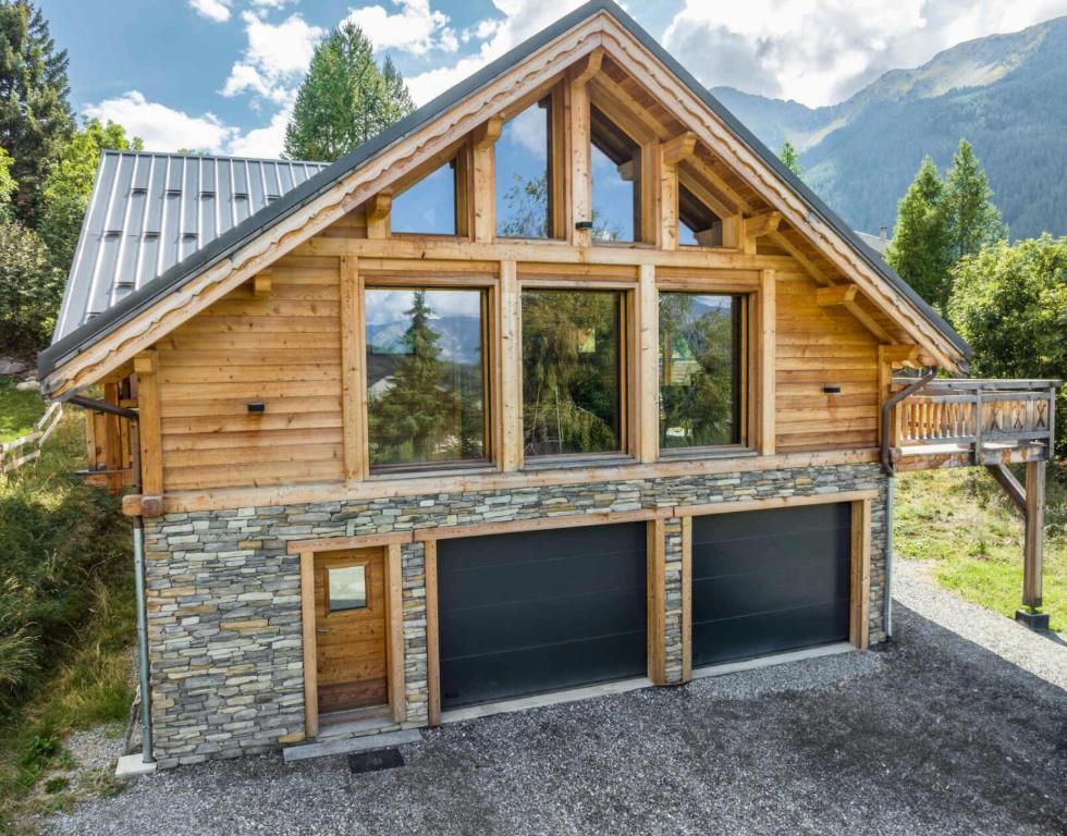 a log home with two garage doors in front at Résidence Pramouton - Chalets pour 6 Personnes 601 in Le Mélézet
