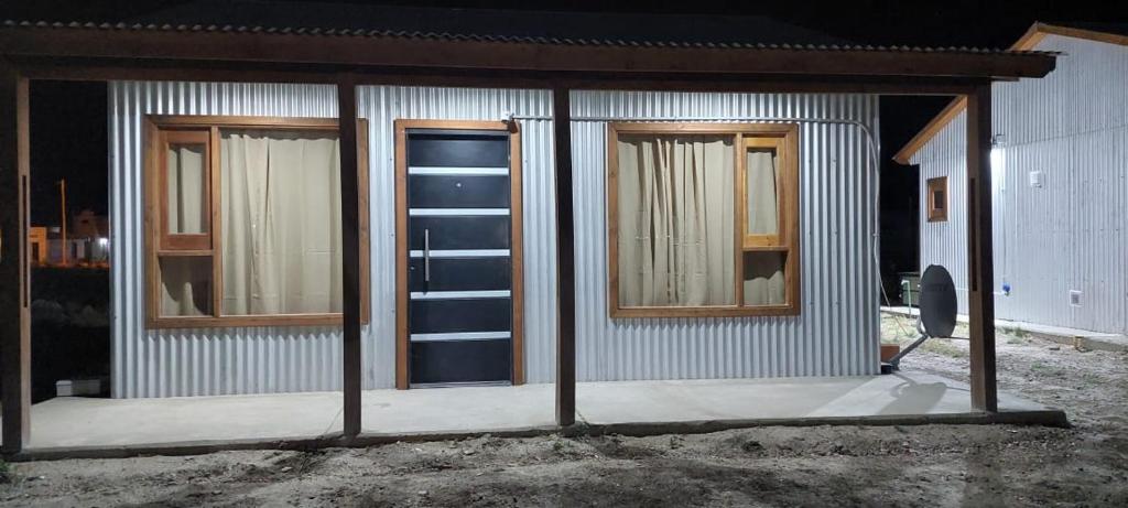 ein Gebäude mit einer Tür und Fenstern darauf in der Unterkunft Cabañas Mailen'S in Puerto San Julian