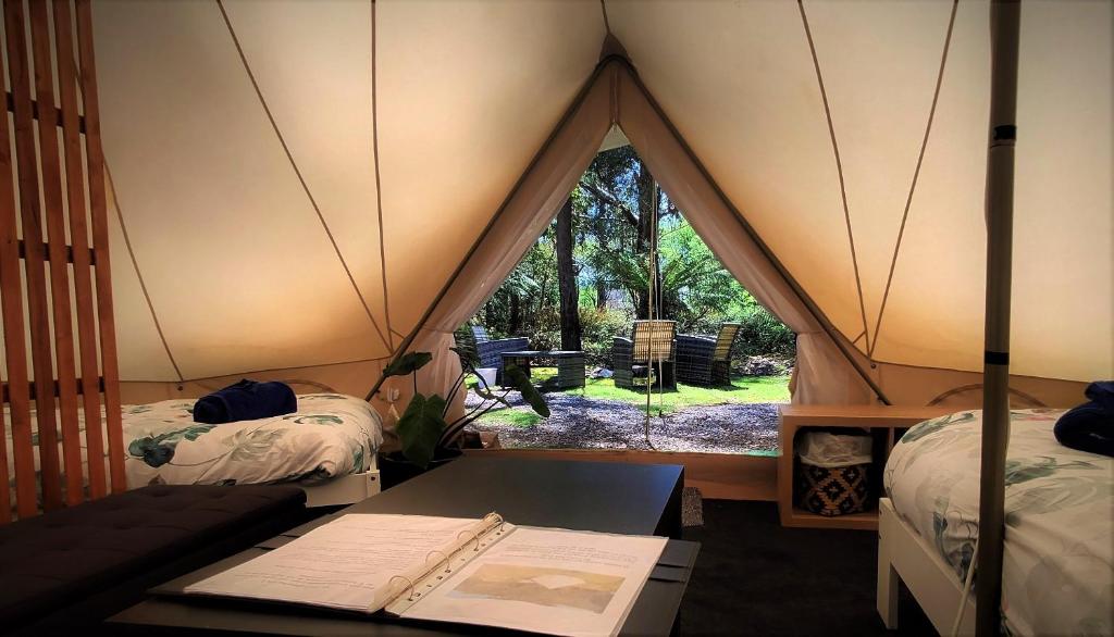 a room with a tent with a table and a window at Glamping at Zeehan Bush Camp in Zeehan