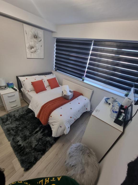 a bedroom with a bed and a desk and a window at Luxurious home in Pitsea