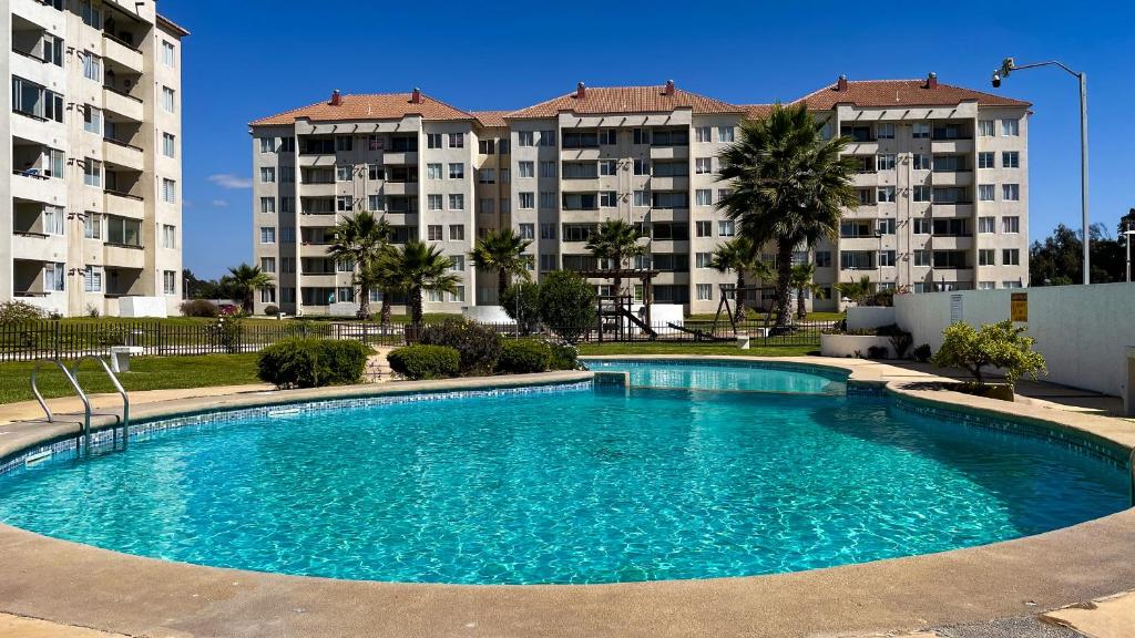 una piscina frente a dos grandes edificios de apartamentos en Departamentos Heimat 3 en La Serena