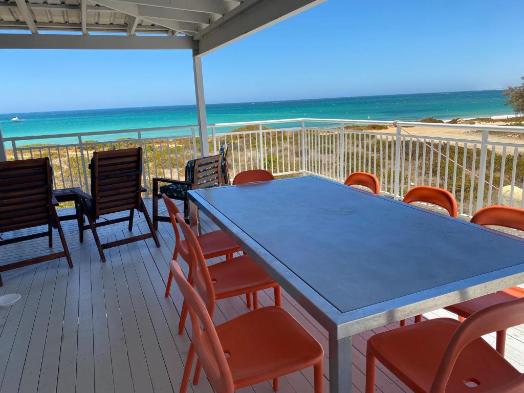 una mesa azul y sillas en una terraza con la playa en Ospreys View - Relaxed Coastal Vibe, en Lancelin
