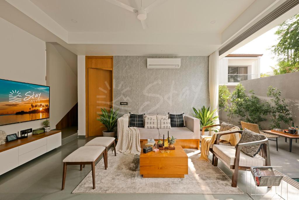 un soggiorno con divano e tavolo di The Banyan Tree Villa A4 by Stay ALYF, Siolim a Siolim