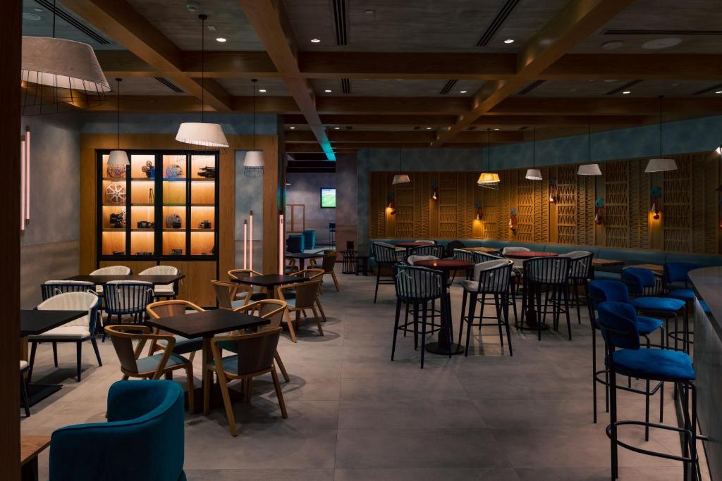 a restaurant with tables and chairs and a bar at ERTH Abu Dhabi Hotel in Abu Dhabi