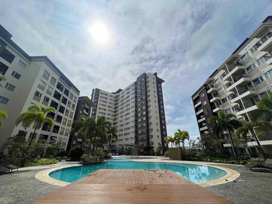 a large swimming pool with two tall buildings at Stylish Iloilo condo w/ Netflix and pool access in Iloilo City