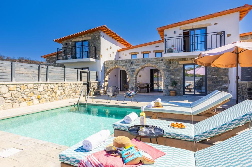 a villa with a swimming pool and a house at La Casa Di Pietre 2 in Kiotari
