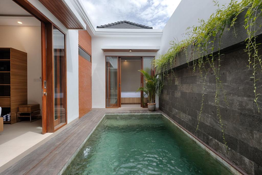 a swimming pool in the middle of a house at Lodji Ubud in Ubud