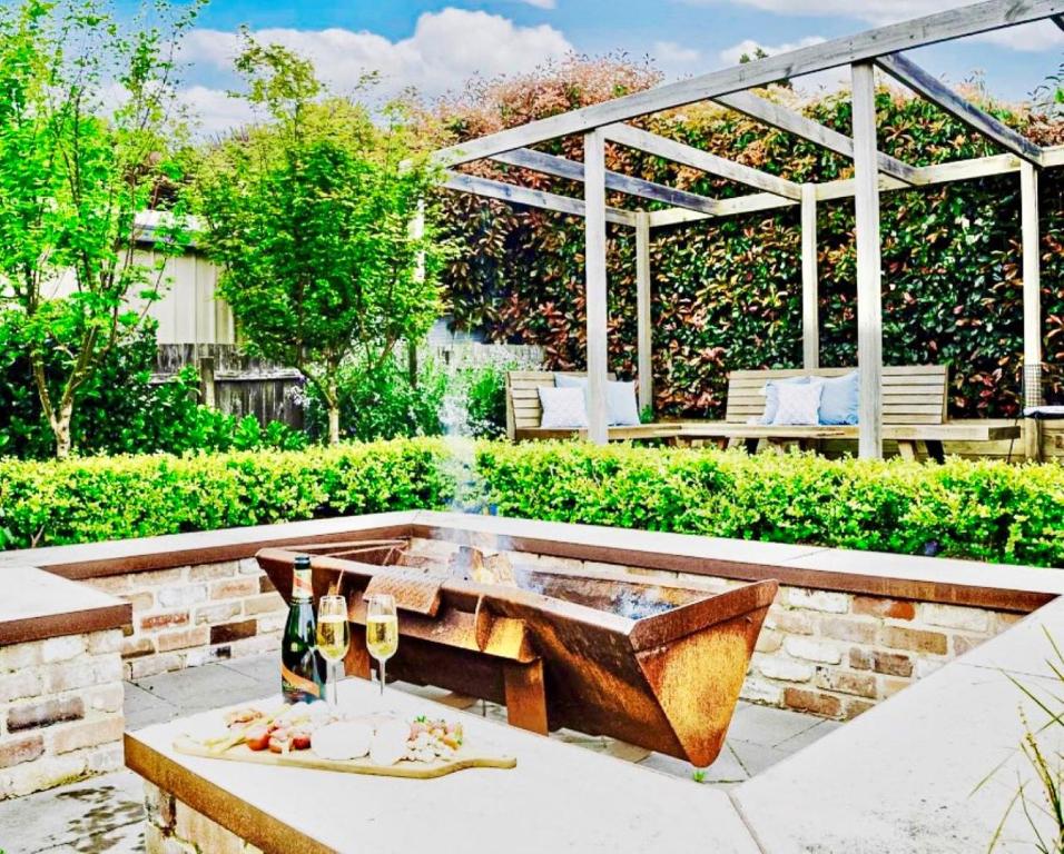 eine Terrasse mit einem Brunnen und einem Tisch mit Weingläsern in der Unterkunft Merrett Vale Home in Moss Vale