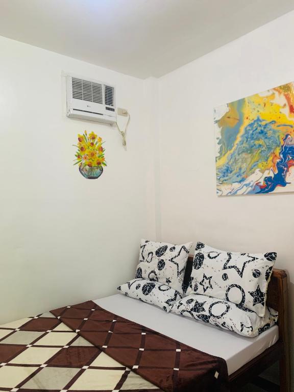 ein Zimmer mit einem Sofa mit Kissen und einem Fenster in der Unterkunft Queen's Room Rental 4 in El Nido