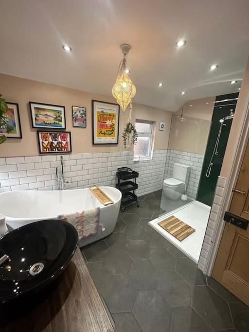 a bathroom with a tub and a sink and a toilet at Ivy Villa in Trench