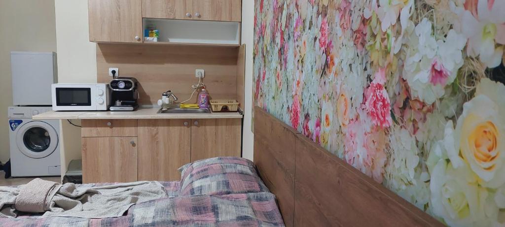 een kamer met een bed en een keuken met een magnetron bij ART 2 in Sliven