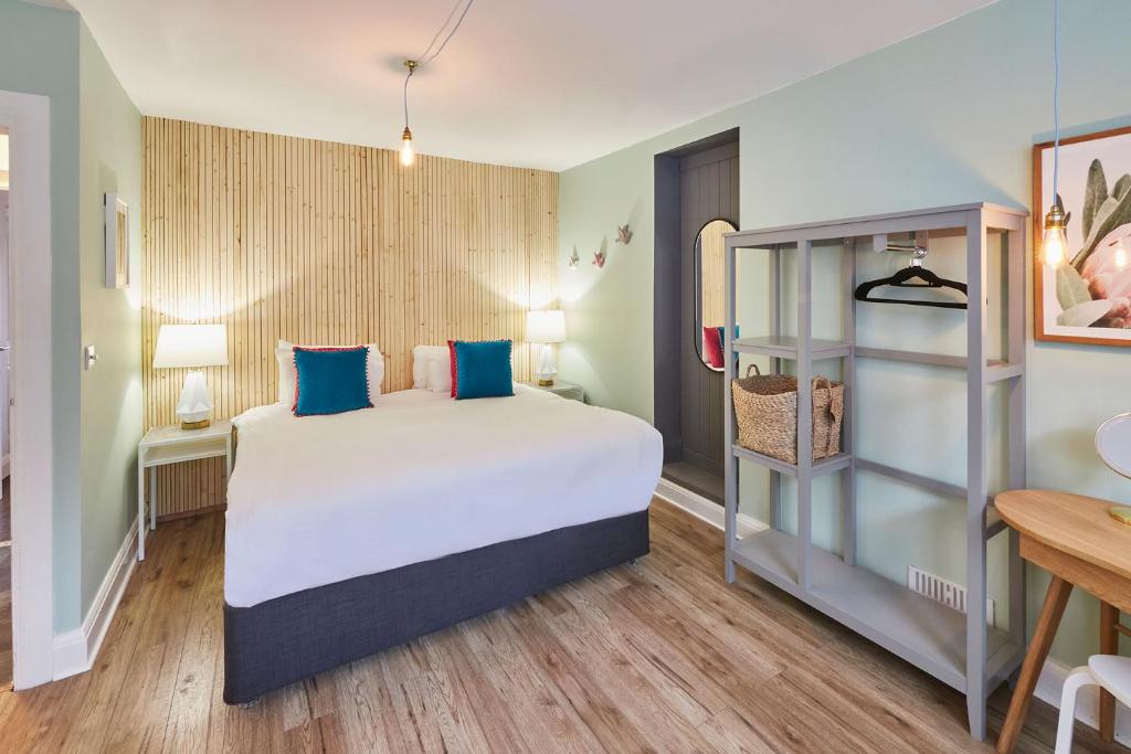 a bedroom with a large bed with blue pillows at South Bay Garden Apartment in Scarborough