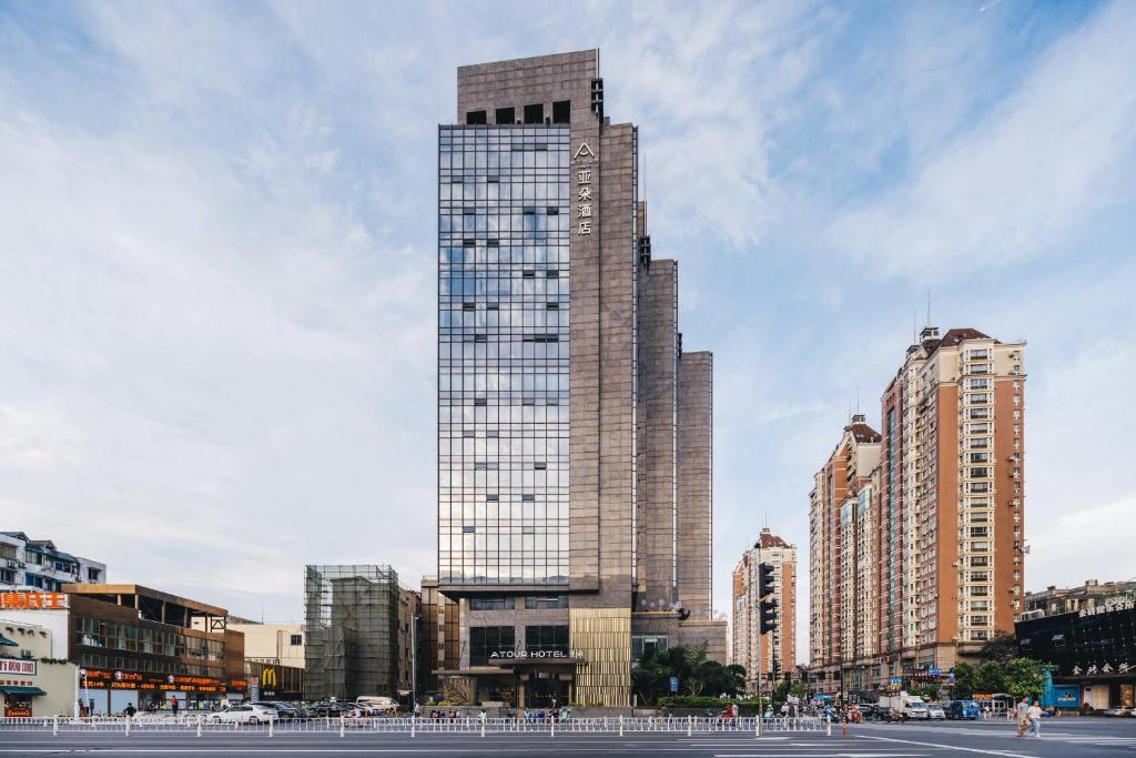 Atour Hotel Hangzhou West Lake Wulin Plaza North Jianguo Road في هانغتشو: مبنى طويل في مدينة بها مباني
