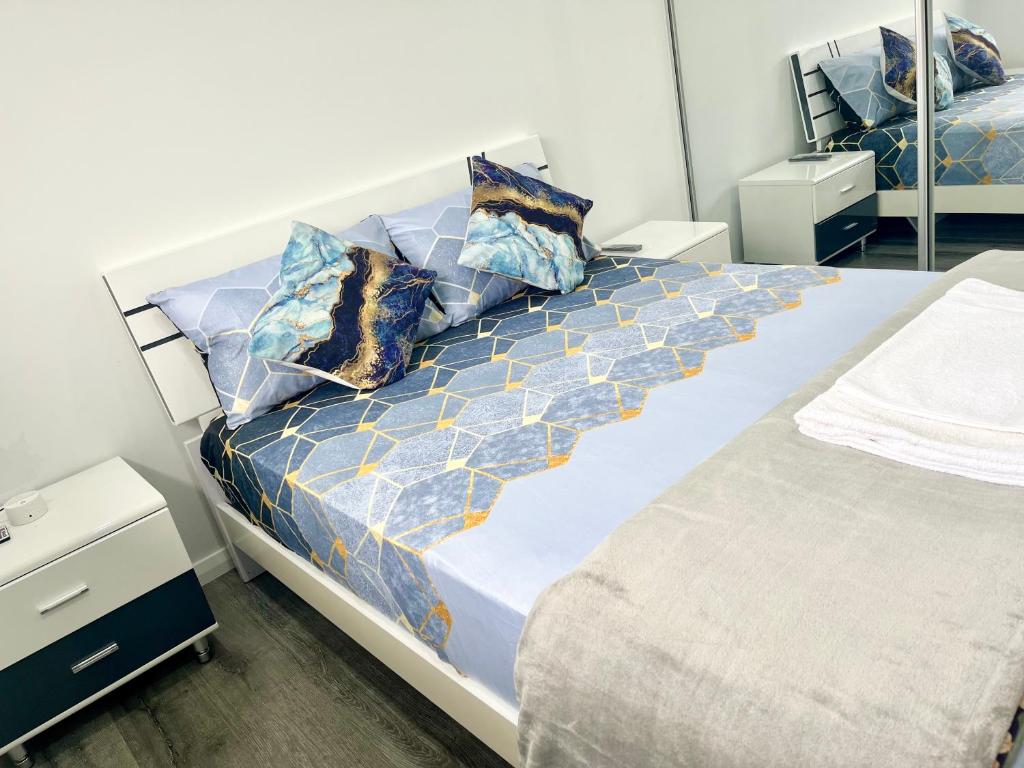 1 dormitorio con 1 cama grande con almohadas azules y doradas en Comfy Queen Bed - Private Bath en Schofields