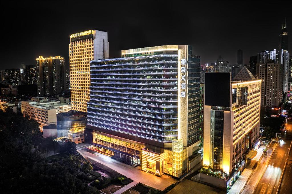 a lit up building in a city at night at Atour X Hotel Shenzhen Luohu Sungang Baoneng Center in Shenzhen