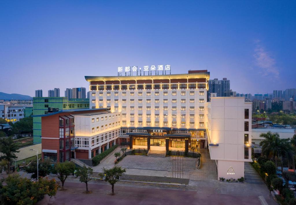 Atour Hotel Huizhou Huiyang New Metropolis في هويزو: مبنى أبيض كبير مع الكثير من النوافذ