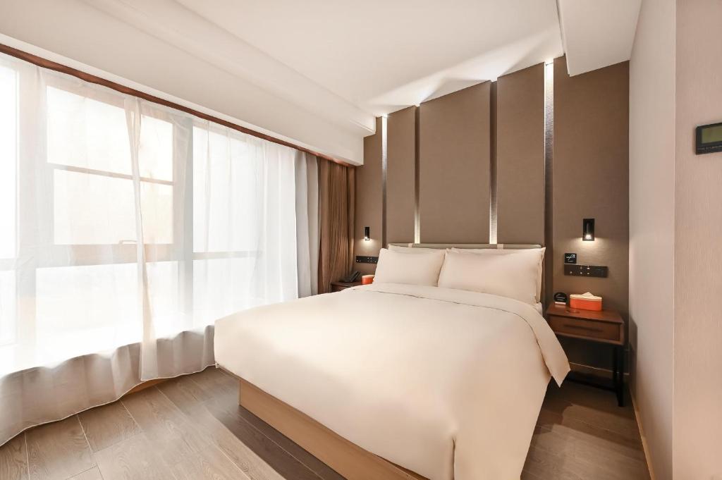 a bedroom with a white bed and a window at Atour Hotel Beijing Lishuiqiao in Changping