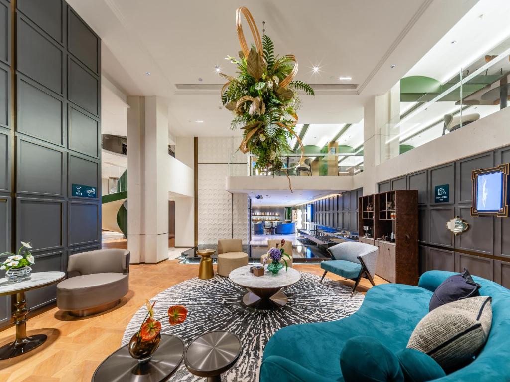 a living room with a blue couch and chairs at Atour Hotel ShanghaiPeople's Square Xintiandi Subway in Shanghai