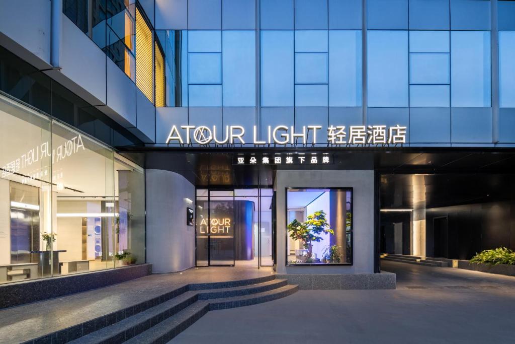 Atour Light Hotel Hangzhou West Lake Wulin Plaza North Huancheng Road في هانغتشو: واجهة متجر مع علامة تنص على ضوء السهم