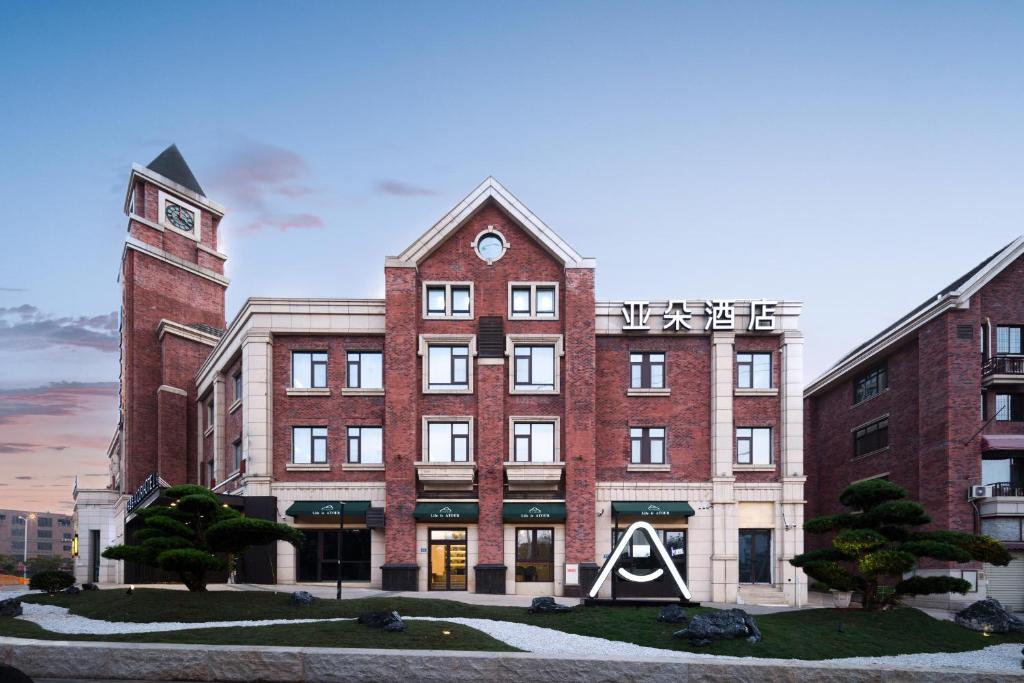 a large red brick building with a clock tower at Atour Hotel Xiamen Xiang'an Torch Industrial Park in Xiang'an