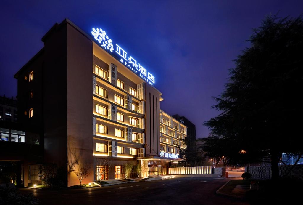 a hotel building with a sign on it at night at Atour Hotel Hangzhou Huanglong in Hangzhou