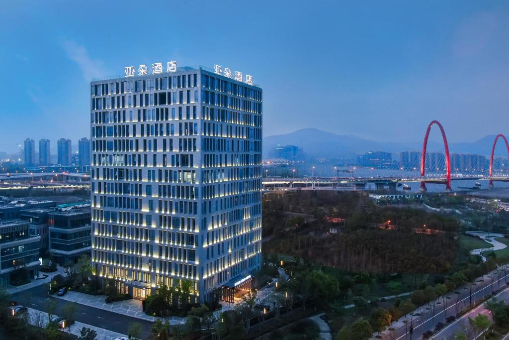 a tall building with lights on in a city at Atour Hotel Zhijiang Bridge in Hangzhou