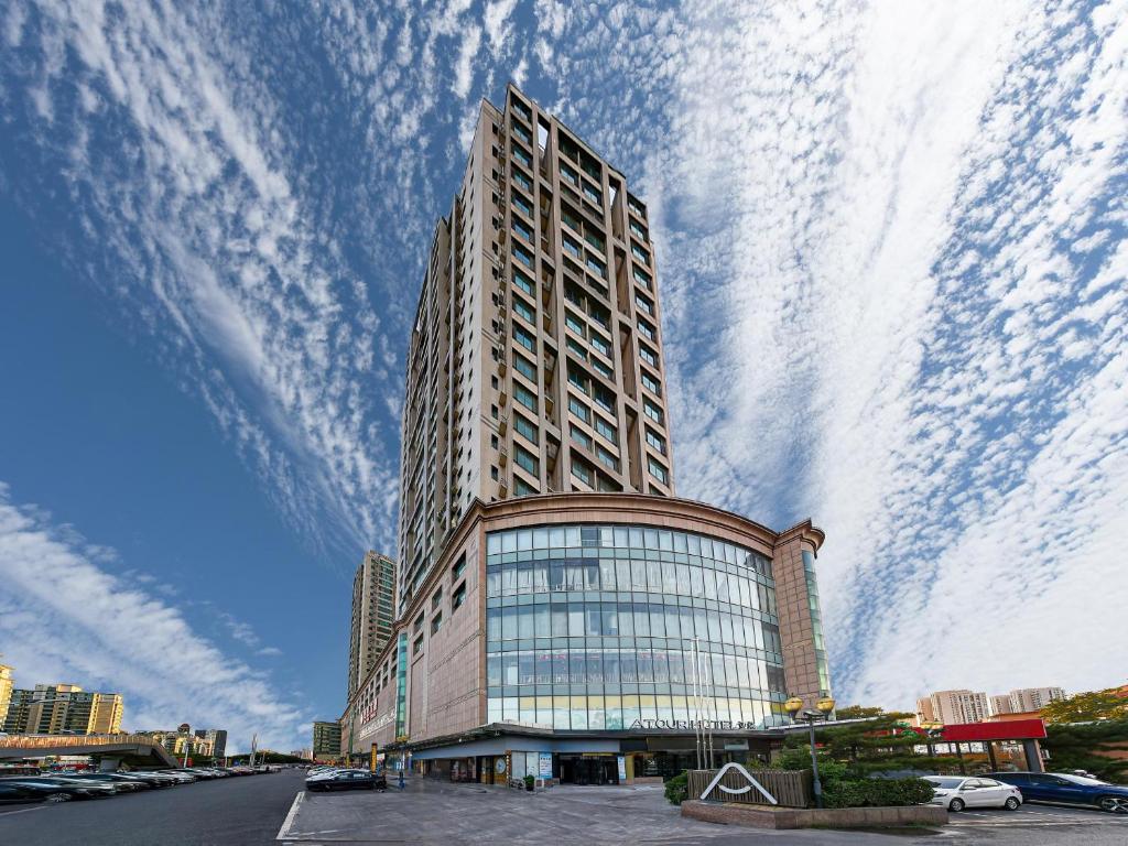 a tall building with a cloudy sky behind it at Atour Hotel Beijing Tongzhou Liyuan Subway Station in Tongzhou