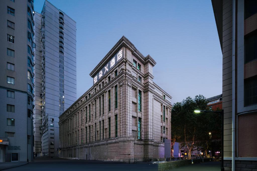 um edifício de tijolos com uma torre de relógio numa cidade em Atour X Hotel Shanghai Xujiahui Sports Center em Xangai