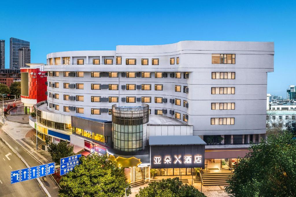 Atour X Hotel Kunming Cultural Palace East Renmin Road في كونمينغ: مبنى ابيض كبير عليه لافته