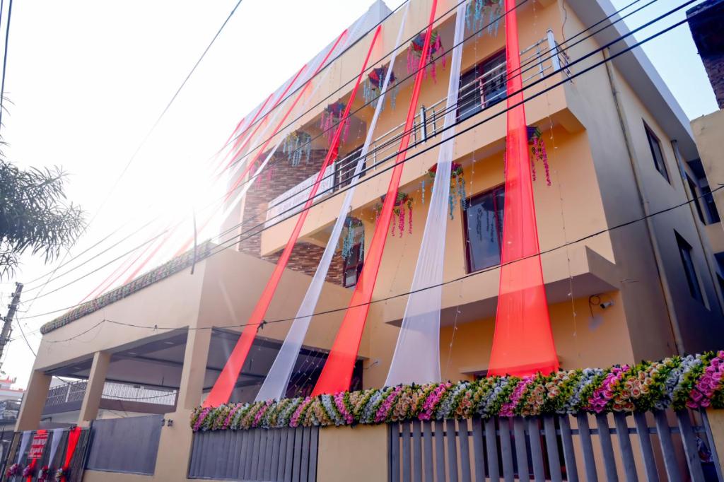 um edifício com postes vermelhos na lateral em Sri Ram Janki Palace em Faizābād