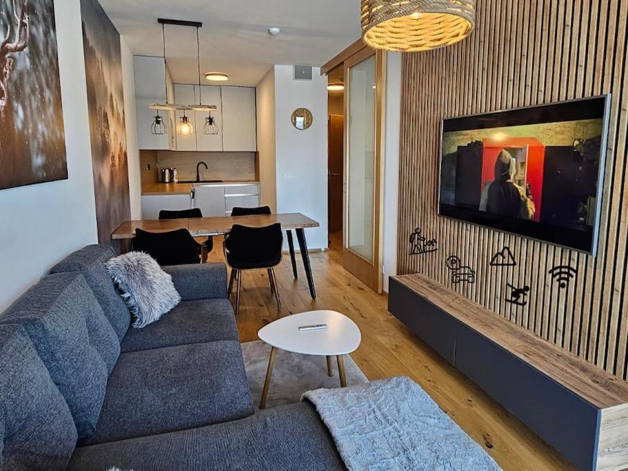 - un salon avec un canapé bleu et une table dans l'établissement Superior apartment s terasou 2 - Janské Lázně, à Janské Lázně