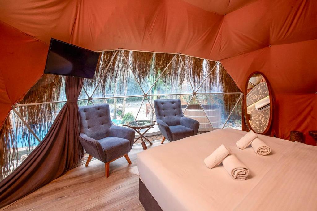 um quarto com uma cama e duas cadeiras numa tenda em Sapanca Paradise River em Sakarya