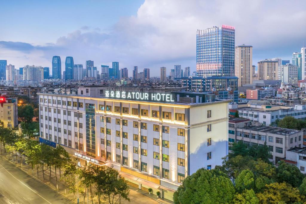 un edificio alberghiero con una città sullo sfondo di Atour Hotel Kunming Yunnan-Burma Avenue a Kunming