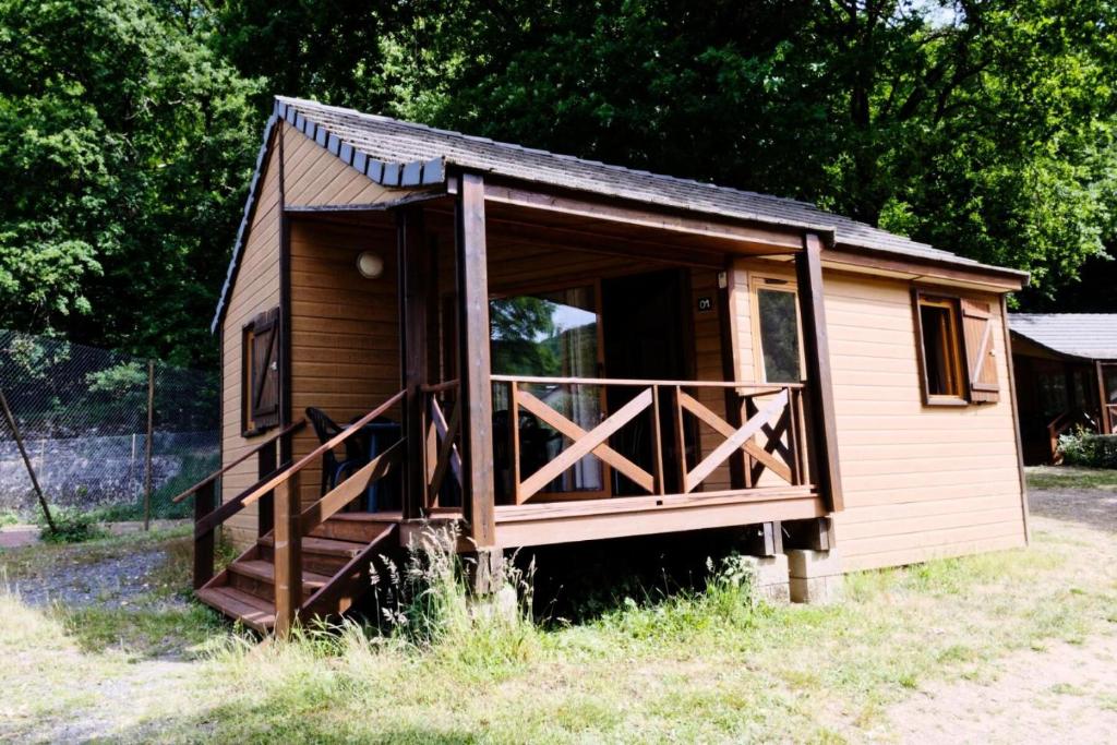 Cabaña pequeña en un campo con porche en Gîte de France Chalet - Gîte de France 4 personnes 504, en Soursac