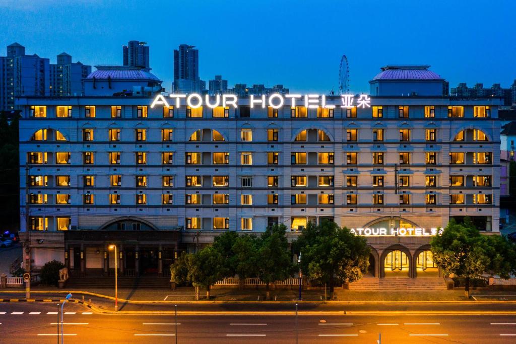 um grande edifício com uma placa à noite em Atour Hotel Shanghai Caohejing em Xangai