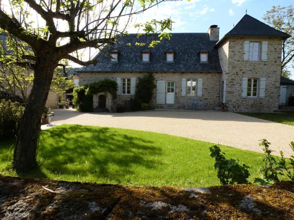 Gîte de France Chez le fustier 4 épis - Gîte de France 6 personnes MAE-8924 في Albussac: منزل حجري كبير مع ممر كبير