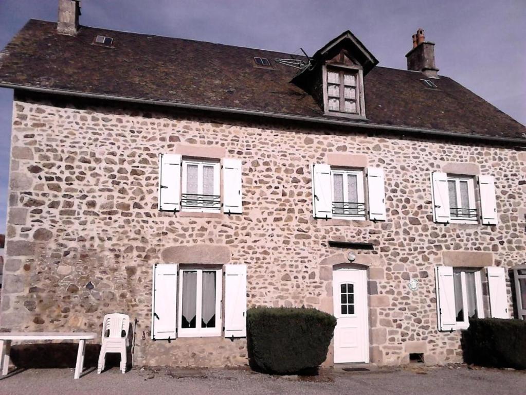 un antiguo edificio de piedra con un banco delante de él en Gîte de France à Couffy-sur-Sarsonne 2 épis - Gîte de France 7 personnes 124, 