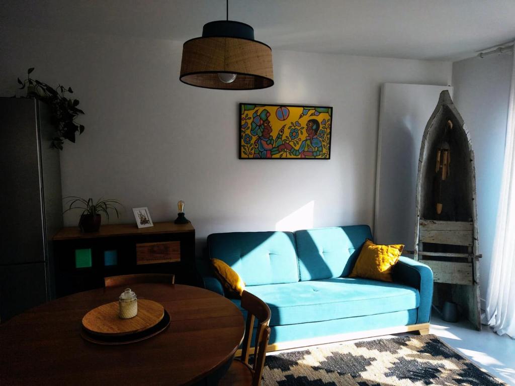 een woonkamer met een blauwe bank en een tafel bij - Pièces 934 in Aix-les-Bains